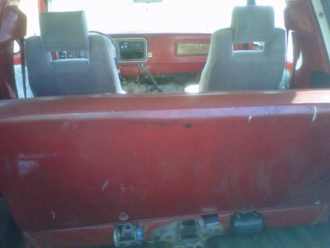 1978 Ford Bronco - Interior view of a red SUV, showing seats, dashboard, and seatbelts.
