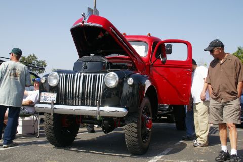1992 Ford Taurus - Vintage truck on display with its hood and door open, attracting onlookers.