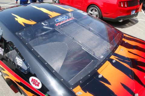 1992 Ford Taurus - A black racing car with flame decals and a Ford Racing sticker is parked next to a red vehicle.