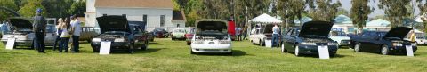 1992 Ford Taurus - Cars are displayed on a grassy field with tents and buildings in the background.