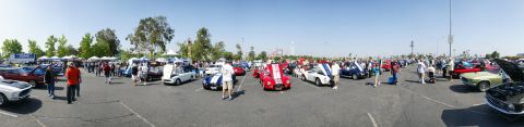 1992 Ford Taurus - A panoramic view captures a vibrant car show filled with classic vehicles and people enjoying the sunny day.