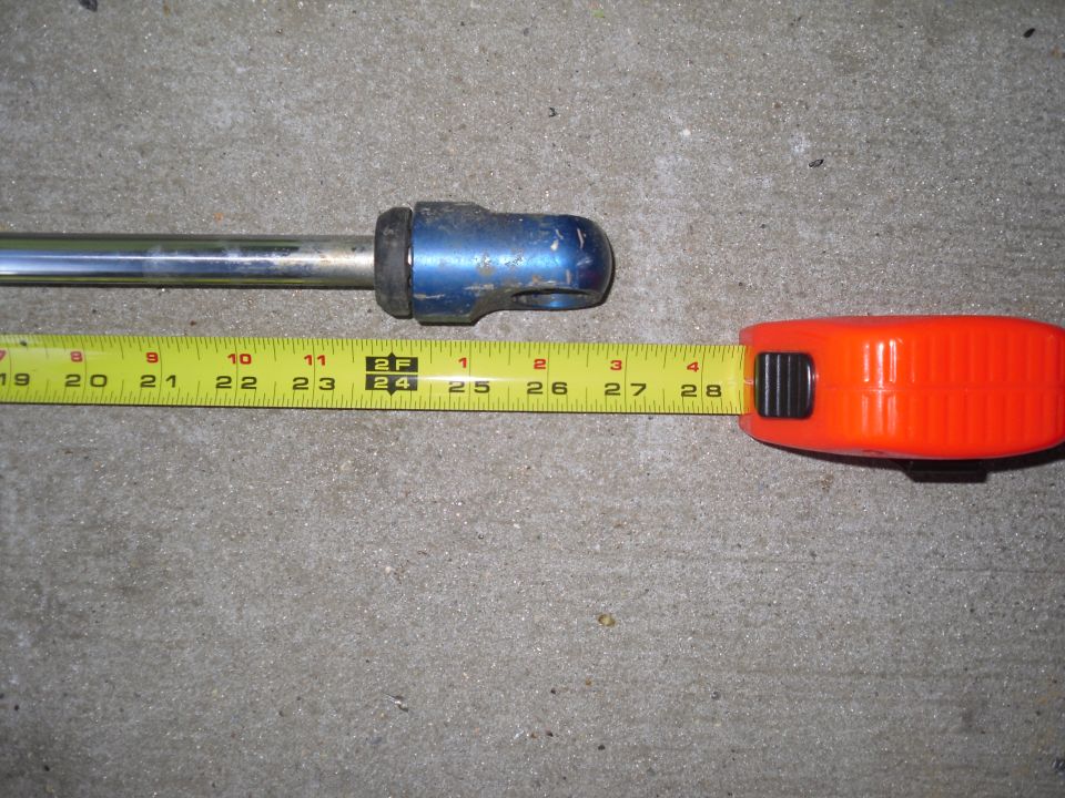 Blue shock absorber measured with a tape measure showing approximately 25 inches