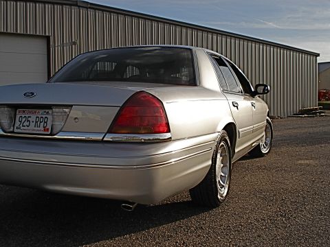 2000 Ford Crown Victoria - A silver 2000 Ford Crown Victoria is seen from the rear quarter angle, parked outdoors.
