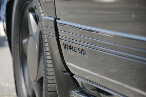 1992 Ford Taurus - Close-up of a black car door showing the "TAURUS SHO" badge, confirming the model year.