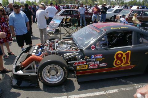 1992 Ford Taurus - A modified race car with its hood open, displaying its engine and various sponsor decals.