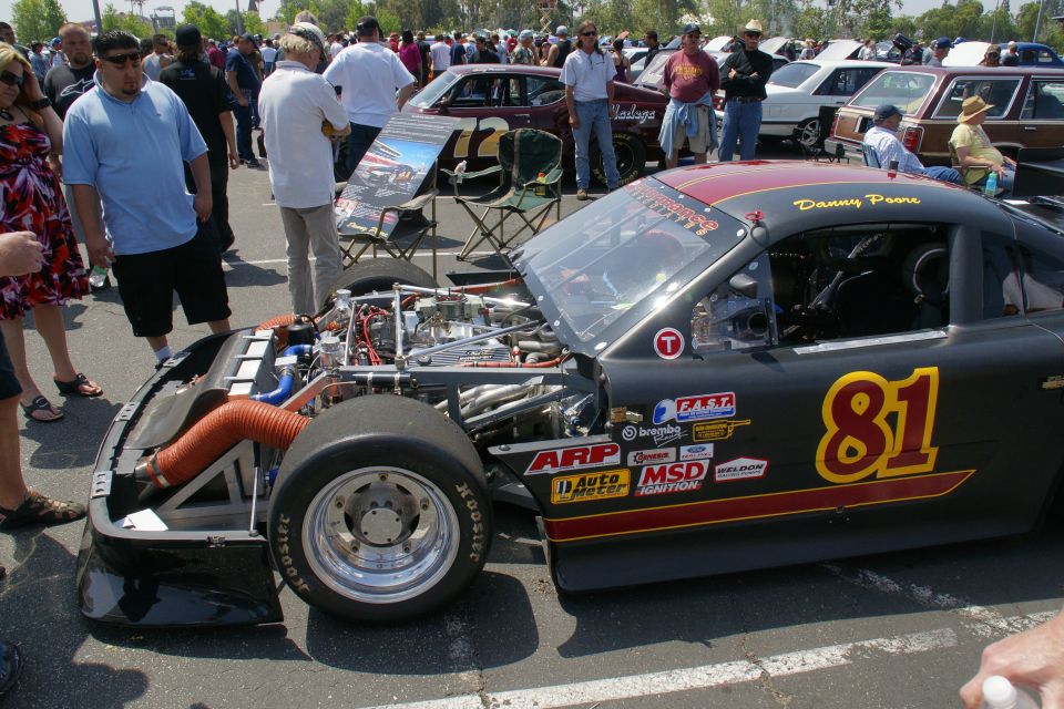 Black race car with number 81, exposed engine, and racing decals