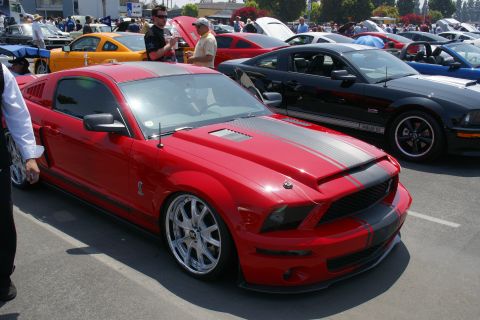 1992 Ford Taurus - Red Ford Mustang Shelby GT500 and black Ford Mustang at a car show.