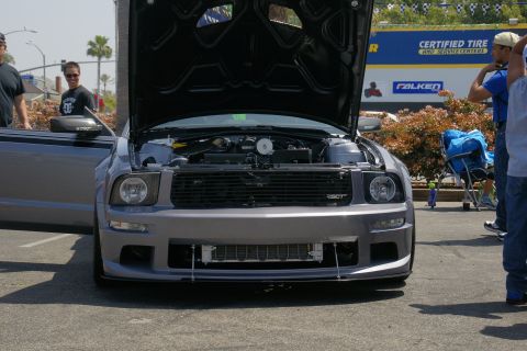 1992 Ford Taurus - A gray Ford Mustang GT is displayed with its hood open, revealing the engine compartment.