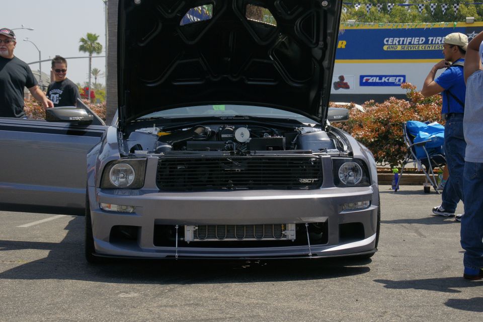 Gray Ford Mustang with hood open, showing engine and intercooler. Front view