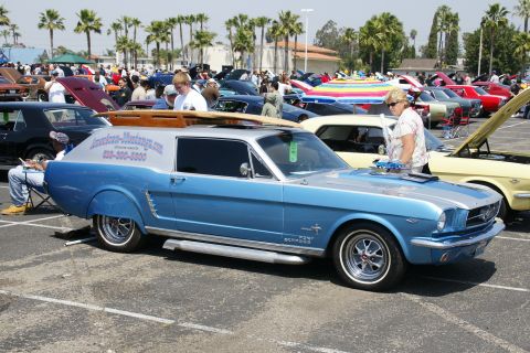 1992 Ford Taurus - Custom 1965 Ford Mustang Station Wagon with surfboard on roof, displayed at a car show.