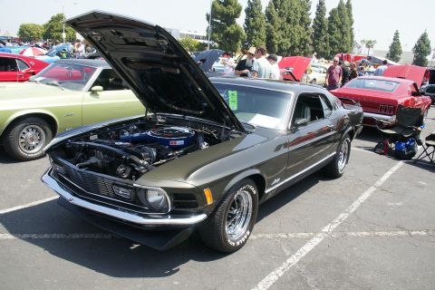 1992 Ford Taurus - A 1970 Ford Mustang Mach 1 is displayed with its hood open at a car show.
