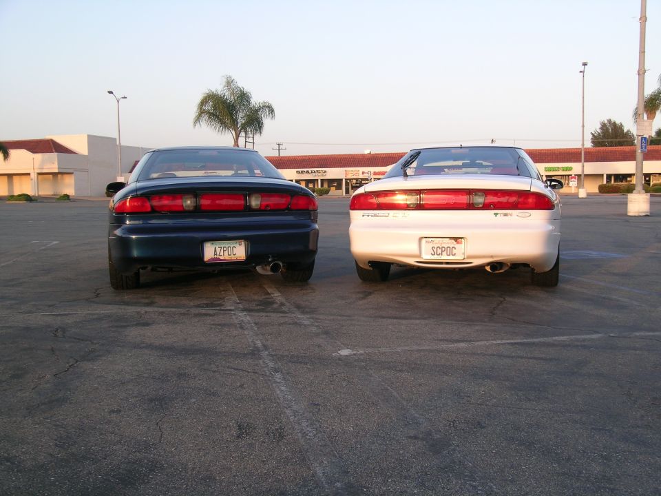 1993 Ford Probe cars parked side-by-side, rear view. Blue car on left, white car on right
