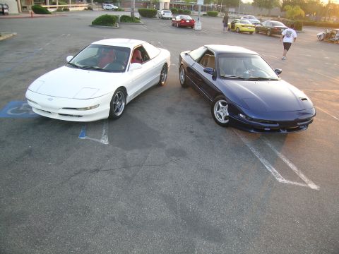 1993 Ford Probe - A pair of 1993 Ford Probes, one in white and the other in blue, are parked side-by-side in an outdoor lot.