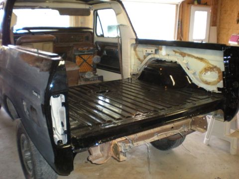 1978 Ford Bronco - The interior and bed of a black pickup truck are shown during a restoration project.