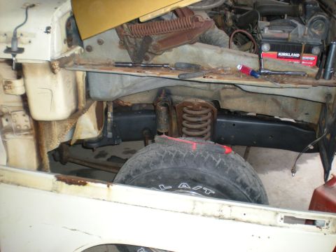 1978 Ford Bronco - The engine bay of a 1978 Ford Bronco shows signs of wear and tear, with a Kirkland battery in place.