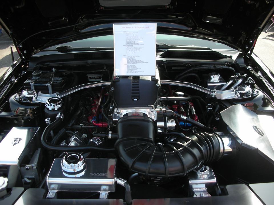 Engine bay with a supercharger, intake, and a document on display