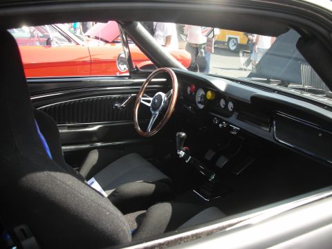 2004 Ford Crown Victoria - Interior of a classic car, possibly a 1965 Ford Mustang, with racing seat and aftermarket gauges.