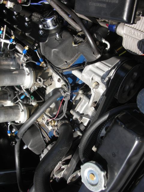 2004 Ford Crown Victoria - Close-up view of a modified engine bay with custom components and braided fuel lines.