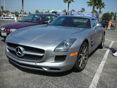 2004 Ford Crown Victoria - A silver Mercedes-Benz SLS AMG is parked in a lot, with a maroon Saturn Ion beside it.