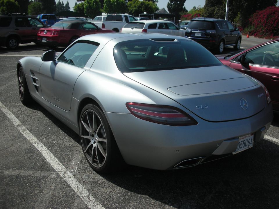 Silver Mercedes-Benz SLS AMG parked in a lot. License plate reads 055064