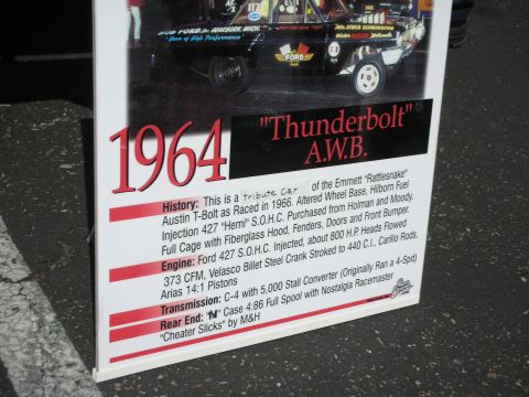 2004 Ford Crown Victoria - A sign displays information about the 1964 Ford Thunderbolt A.W.B., detailing its history and specifications.