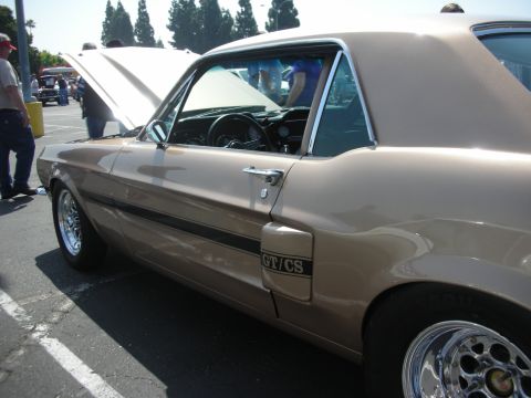 2004 Ford Crown Victoria - Tan 1967 Ford Mustang GT/CS coupe with black side stripe and chrome wheels.