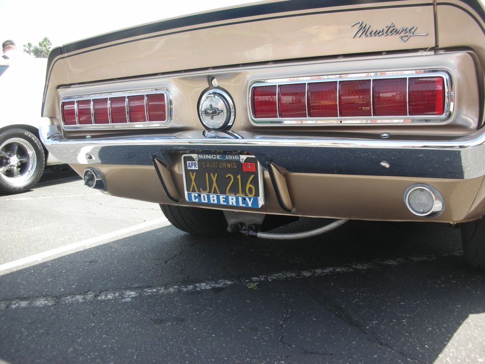 Gold 1969 Ford Mustang rear view with horizontal taillights and California license plate XJX 216