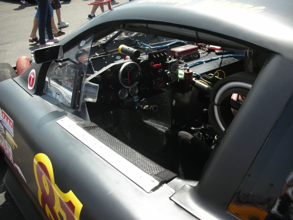 Custom dashboard and interior of a race car, showing gauges, wiring, and a steering wheel