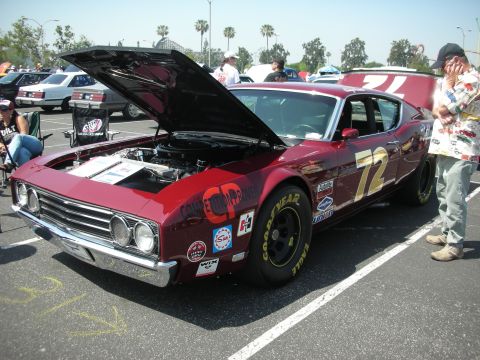 2004 Ford Crown Victoria - A maroon race car with its hood open is parked at an outdoor event, with spectators nearby.