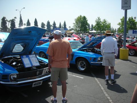 2004 Ford Crown Victoria - A blue 1970 Ford Mustang Boss 302 is displayed with its hood open at a car show.