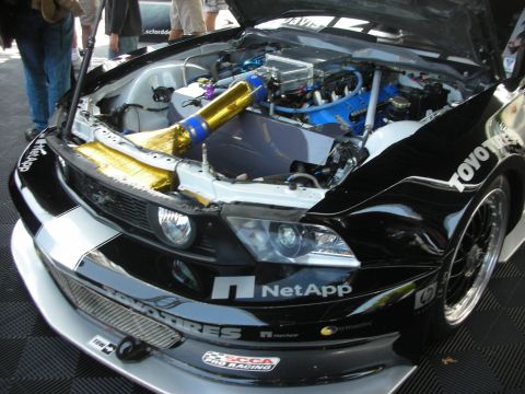 2004 Ford Crown Victoria - Customized Ford Mustang with engine exposed, aftermarket parts and sponsor decals.