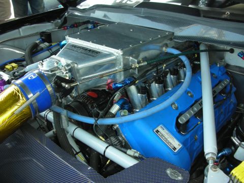 2004 Ford Crown Victoria - Close-up of a modified Ford engine, likely for racing, with prominent blue valve covers and a large supercharger assembly.
