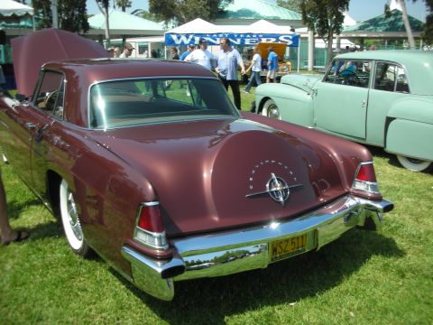 2004 Ford Crown Victoria - A classic Lincoln coupe with a distinctive rear design is displayed at an outdoor car show.