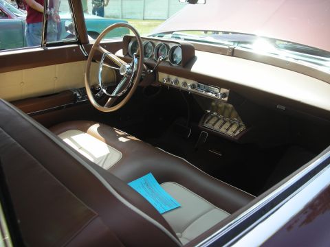 2004 Ford Crown Victoria - The interior of a classic car features a large steering wheel and a dashboard with multiple gauges and a radio.