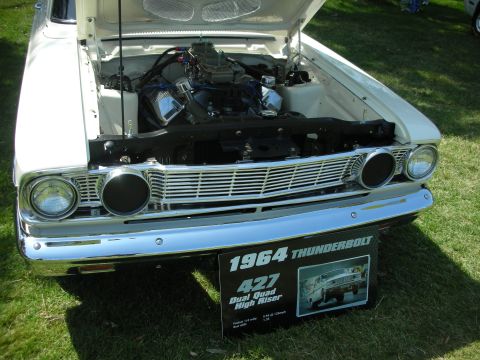 2004 Ford Crown Victoria - A 1964 Ford Thunderbolt is displayed with its hood open, revealing the engine and a descriptive sign.