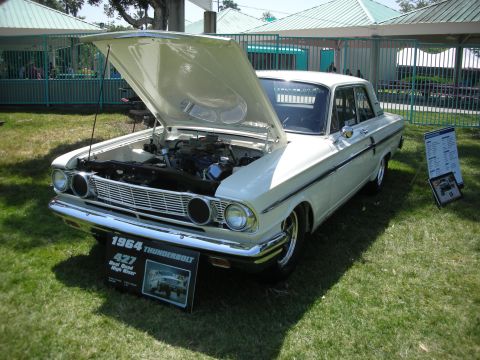 2004 Ford Crown Victoria - A white 1964 Ford Thunderbolt is displayed with its hood open, revealing the engine bay.