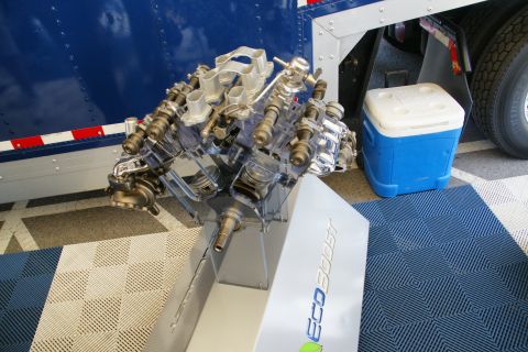 1992 Ford Taurus - A clear display engine labeled EcoBoost is shown next to a blue cooler and a large truck tire.