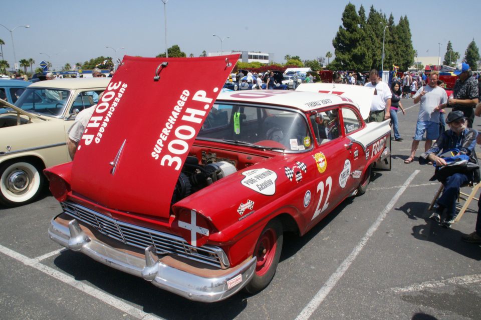 Red and white race car with hood open, showing "SUPERCHARGED 300 H.P."