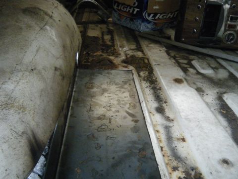 1981 Ford E350 - Interior floor of a vehicle, showing a metal patch and signs of wear and tear.