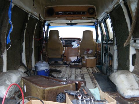 1981 Ford E350 - The interior of a 1981 Ford E350 van shows seats and dashboard, with insulation removed.