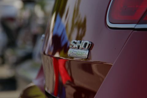 1992 Ford Taurus - Close-up of a SHO EcoBoost badge on the rear of a red vehicle.