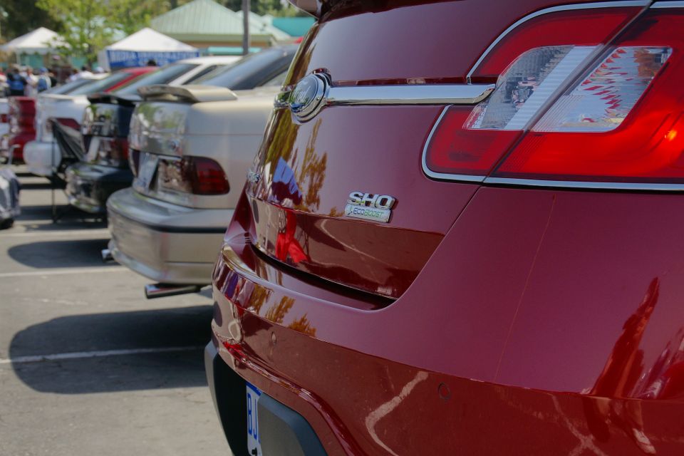Rear of a red SHO Taurus with a chrome strip and taillight detail