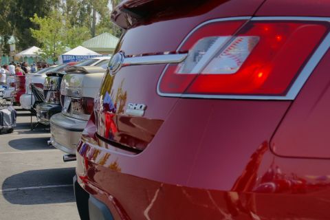 1992 Ford Taurus - A red Ford Taurus SHO is parked in a line of cars at an outdoor event.