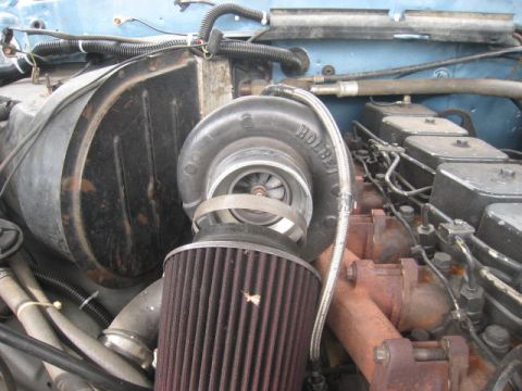 1976 Ford F-250 - Close-up view of a turbocharger and air filter within an engine bay, showing various engine components.