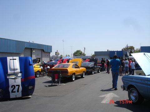 1978 Ford Mustang II - A car show event is underway with several vehicles on display under a clear sky.