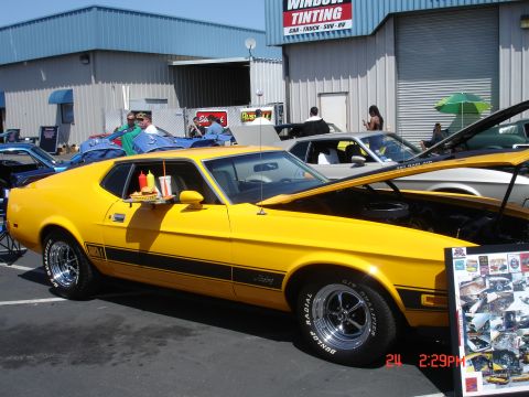 1978 Ford Mustang II - A yellow 1971 Ford Mustang Mach 1 is parked with a fast food tray on its driver's side window.
