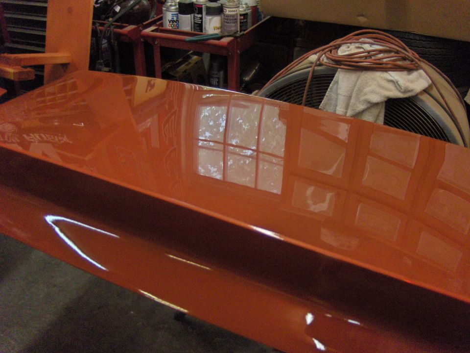 orange painted car panel with reflections