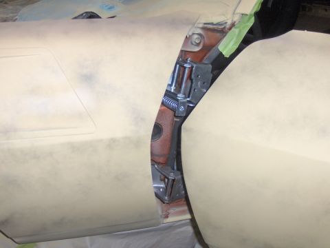 1980 Chevrolet Camaro - Close-up of a car's door hinge area, with primer applied to the body panels.