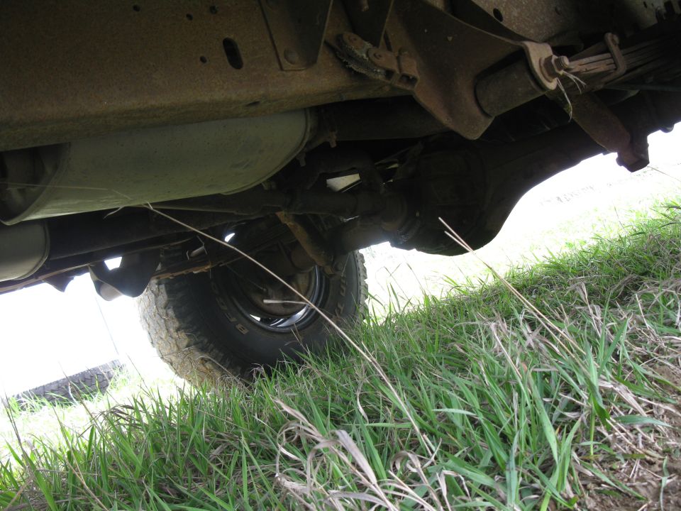 Underside view of a vehicle's rear axle, leaf springs, and exhaust system