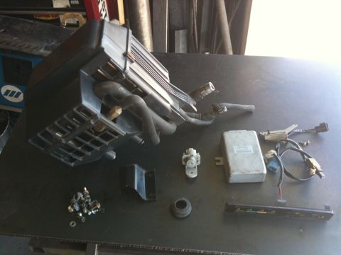 1987 Suzuki Samurai - Various automotive components are displayed on a flat surface, suggesting a repair or upgrade project.